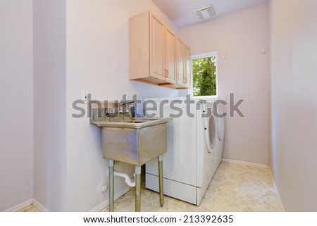 Small laundry room with white appliances, two cabinets and old sink