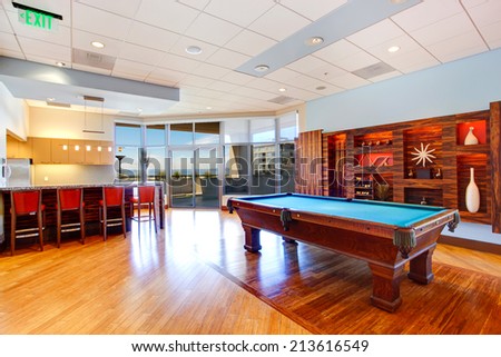Entertainment room with pool table and walkout deck in residential building
