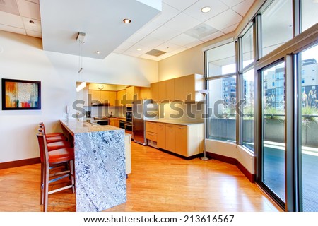 Kitchen room with marble counter top and red stools. View of glass door to walkout deck