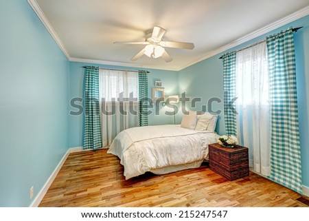 Cheerful light blue bedroom with turquoise curtains and white bedding