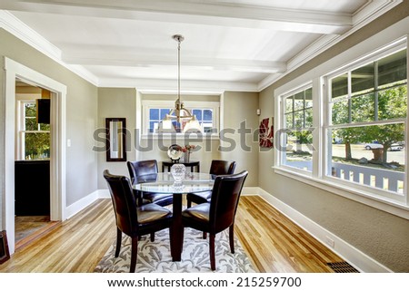 Dining set. Glass round top table with leather chairs. Bright room with windows is perfect for dining area