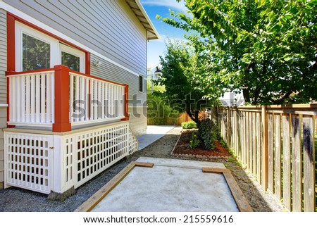 House exterior with small deck with white railings and orange trim