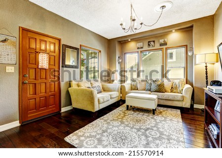 Simple living room interior. Comfortable couches with ottoman and rug on hardwood floor