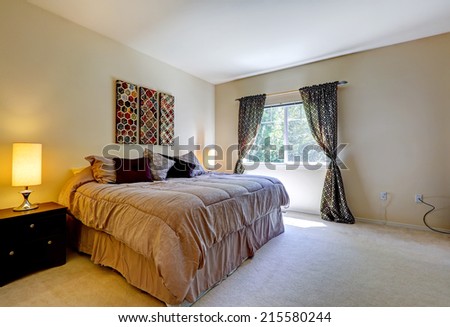 Cozy bedroom with window, black curtains and light brown bed