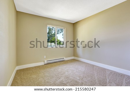 Room in empty house.  Simple bedroom with window and brown carpet floor
