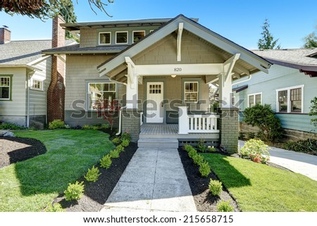 House entrance porch with white wooden door and white railings. Front yard landscape with walkway