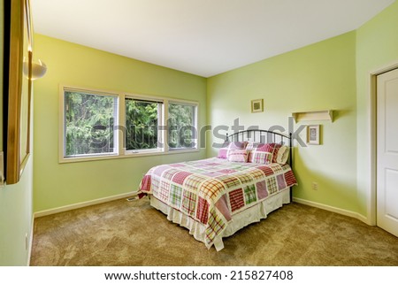 Bright lime bedroom with iron frame bed and colorful bedding
