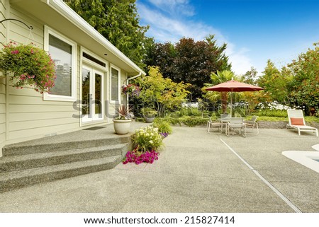 Backyard with flower pots and patio table set with umbrella. Real estate in Federal Way, WA