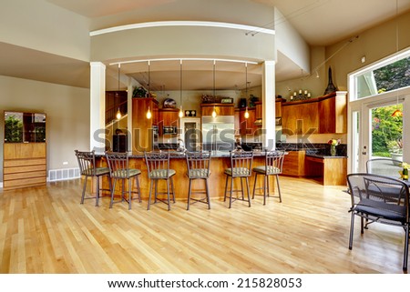 Spacious luxury kitchen room with columns and round granite counter top with stools
