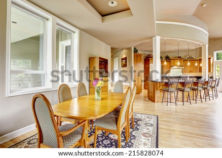 Spacious luxury kitchen room with columns and round granite counter top with stools. Elegant dining table set