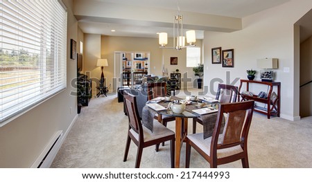 Modern apartment interior with open floor plan. DIning area with served round table and chairs