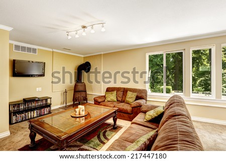 Cozy room with comfortable sofa, love seat and carved wood coffee table. Antique stove