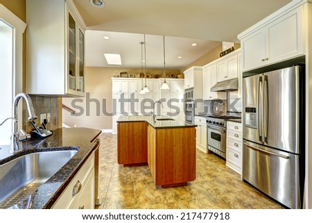 Bright kitchen room with granite tops, kitchen island and white cabinets