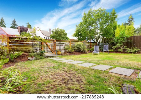 Green front yard with wooden fence and gate.