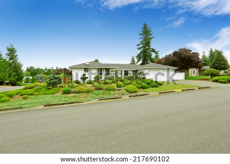 House with beautiful curb appeal. Green landscape with decorative trees and lawn
