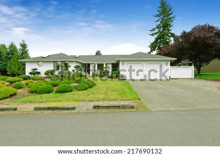 House with beautiful curb appeal. Green landscape with decorative trees and lawn
