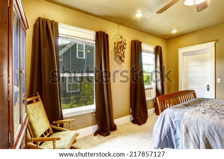 Warm tones bedroom with light yellow walls and brown curtains