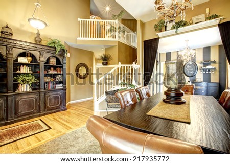 House with open floor plan. View of dining table , carved wood antique cabinet and wine tasting area