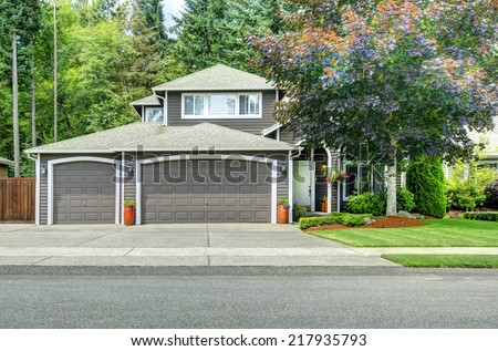 American house with landscape design. View of entrance porch and garage