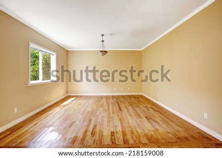 Empty house in light ivory color with hardwood floor and small window