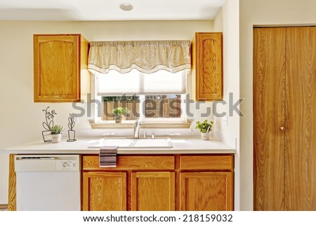 Countryside house interior. Kitchen room with wooden storage cabinets and window view