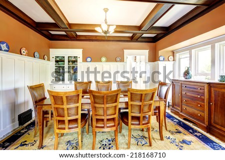 Large dining table set in brown room with white trim and coffered ceiling