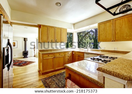 Simple kitchen interior with wooden cabinets and granite tops.