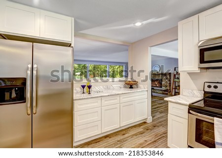 White cabinets with steel refrigerator