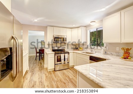 White cabinets with steel appliances and hardwood floor