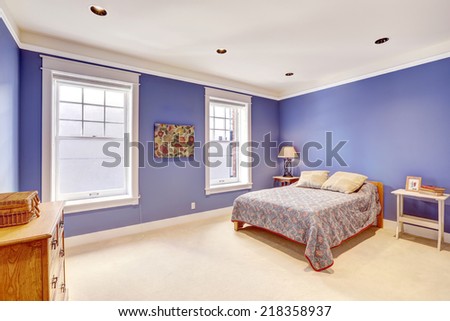 Bright purple bedroom with practical furniture