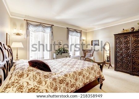 Bedroom with beautiful carved wood bed , wardrobe and antique chair with mirror