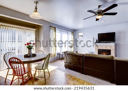 Rustic dining table with tulips in light blue living room with fireplace and tv