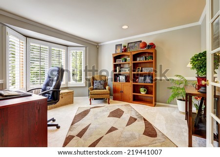 Spacious office room with cabinet, antique armchair, desk