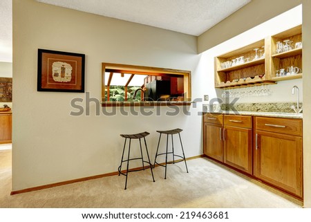 Bar counter top in the wall between kitchen and dining area. Kitchen cabinets with granite top