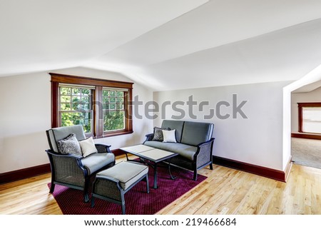 Comfort sitting area with vaulted ceiling. Couch with table and armchair on burgundy rug