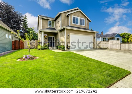 Two story house exterior with white door garage and driveway