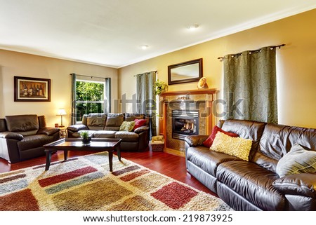 Living room interior with leather couches and colorful soft rug