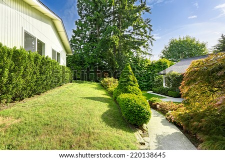 House exterior with concrete walkway and trimmed hedges