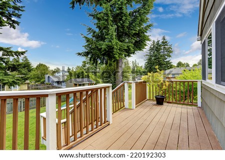 Walkout deck in brown and white trim overlooking backyard area