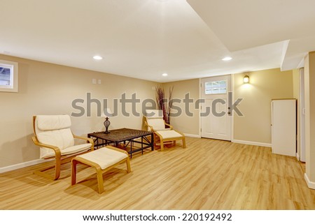 Bright room with new hardwood floor and ivory walls. Tropical style furniture set with dry branches in the corner