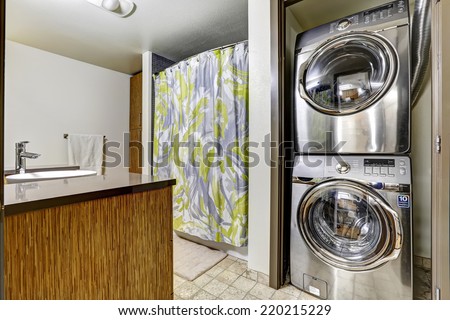 Bathroom with laundry room. Shiny steel washer and dryer