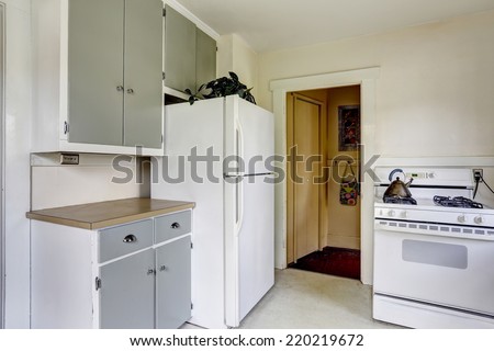 Simple kitchen interior with white stove and refrigerator in old house