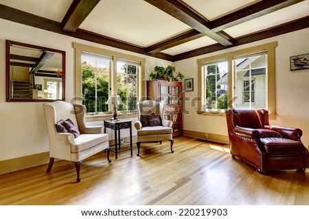Living room with sitting area. Comfortable leather armchair and two antique chairs with small table