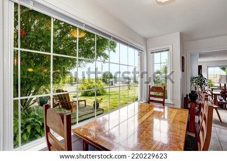 Bright dining area with large french window. Backyard view with patio area