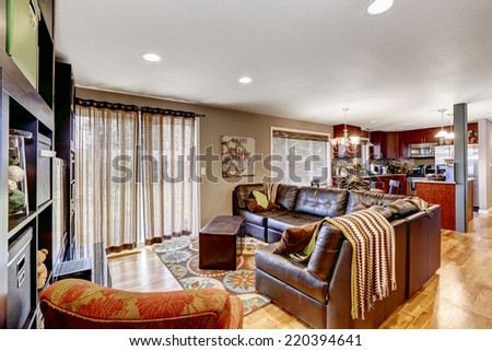 Cozy family room with leather couch bright kitchen area with burgundy cabinets