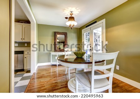 Dining table set in room with green wall and white french door