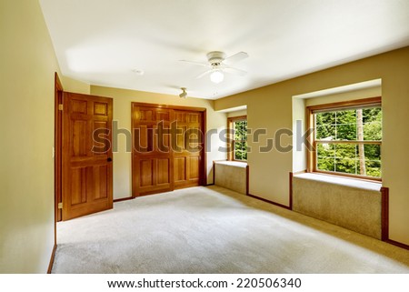 Empty room with window seats, carpet floor and closet
