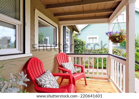 Cozy walkout deck with red chairs. Deck with with railings and wooden floor