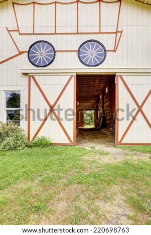 Empty horse barn exterior with red trim