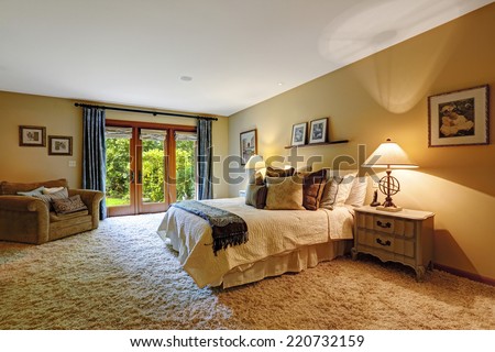 Master bedroom interior with exit to backyard.  Soft rug and queen bed with pillows create comfort interior